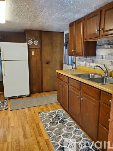A kitchen with a white fridge and wooden cabinets.