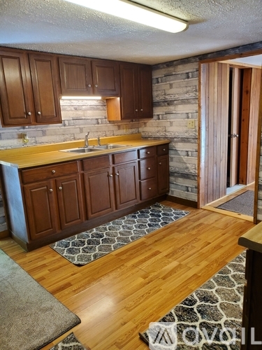 A kitchen with wooden cabinets and a stone backsplash.