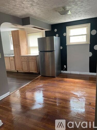 A kitchen with wooden cabinets and a refrigerator.