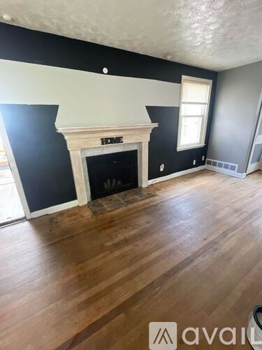 A room with a fireplace and wooden floors.
