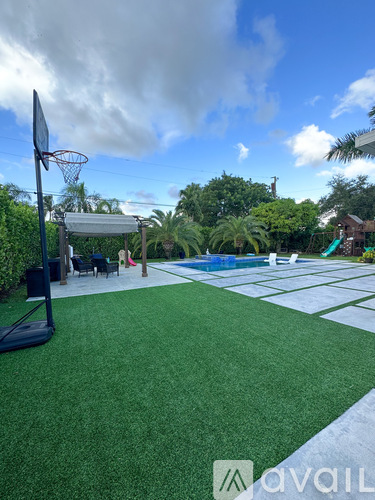 A backyard with a basketball hoop and a pool table.