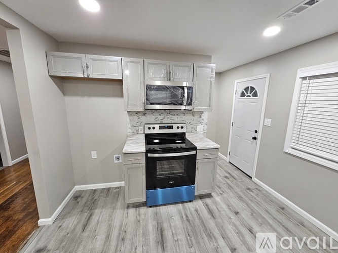 A kitchen with a stove top oven and cabinets above it.