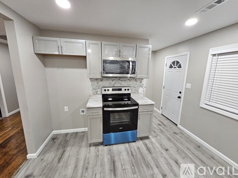 A kitchen with a stove top oven and cabinets above it.