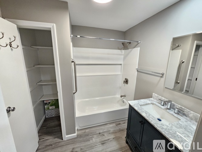 A bathroom with a white tub, sink, and a walk-in shower.