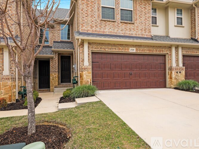 A house with a brown garage door and a tree in front.
