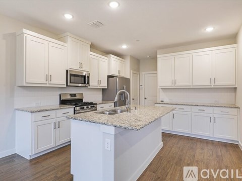 A kitchen with white cabinets and a granite countertop.