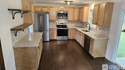 A kitchen with wooden cabinets and a refrigerator.