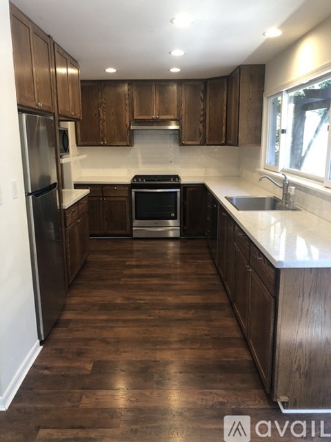 A kitchen with wooden cabinets and a stainless steel refrigerator.