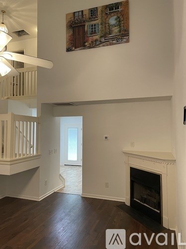 A living room with a fireplace and a painting on the wall.