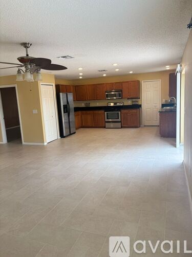 A spacious kitchen with wooden cabinets and a refrigerator.