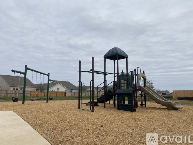 A playground with a slide, swings, and a tower.