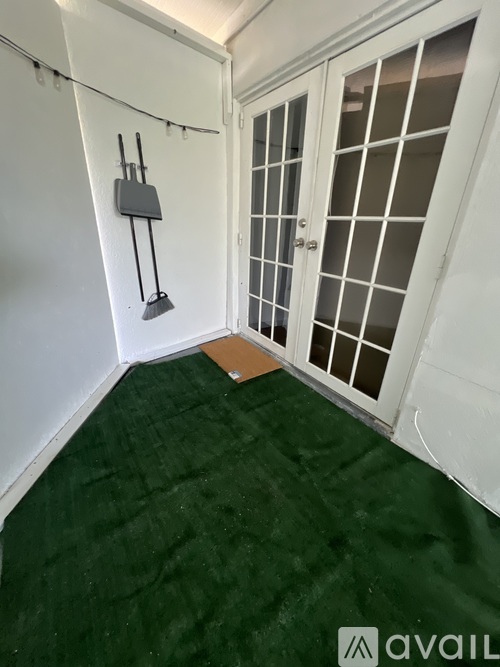 A room with a white door and a green carpet.