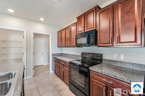 A kitchen with copper cabinets and black appliances.