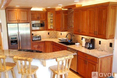 A kitchen with wooden cabinets and granite countertops.
