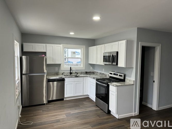 A modern kitchen with white cabinets and stainless steel appliances.