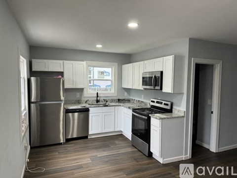 A modern kitchen with white cabinets and stainless steel appliances.