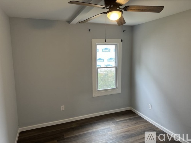A room with a ceiling fan and a window.