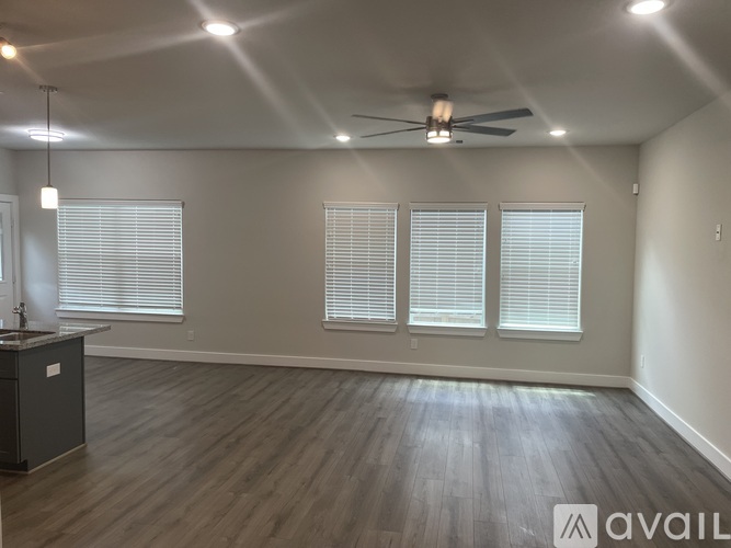 A spacious room with a ceiling fan and wooden flooring.