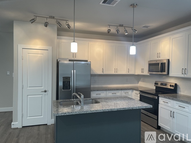 A kitchen with a granite countertop and stainless steel appliances.
