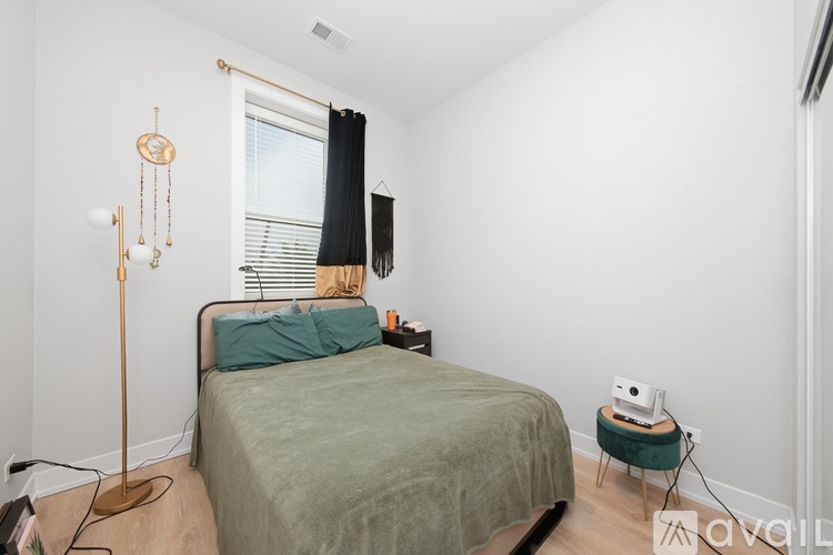 A bedroom with a bed, a chair, and a lamp.