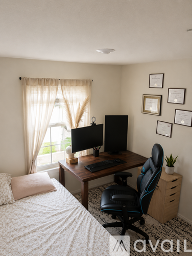 A bedroom with a bed, desk, and chair.