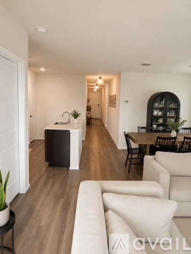 A living room with a white couch and a wooden floor.
