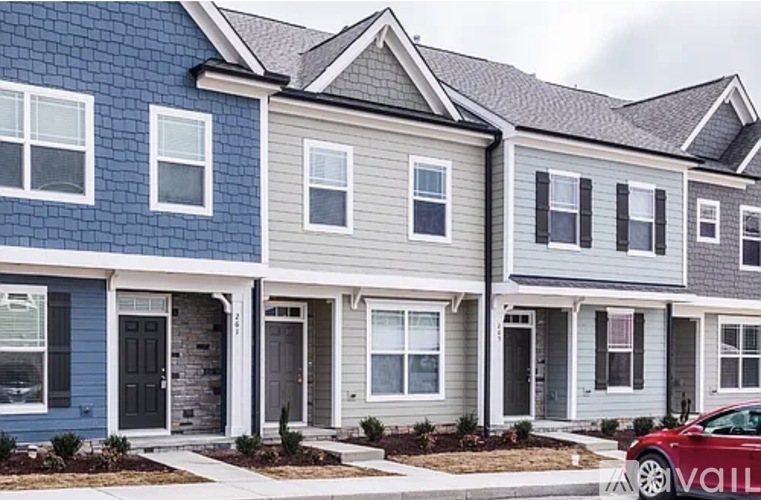 A row of houses with a car parked in front of the first one.
