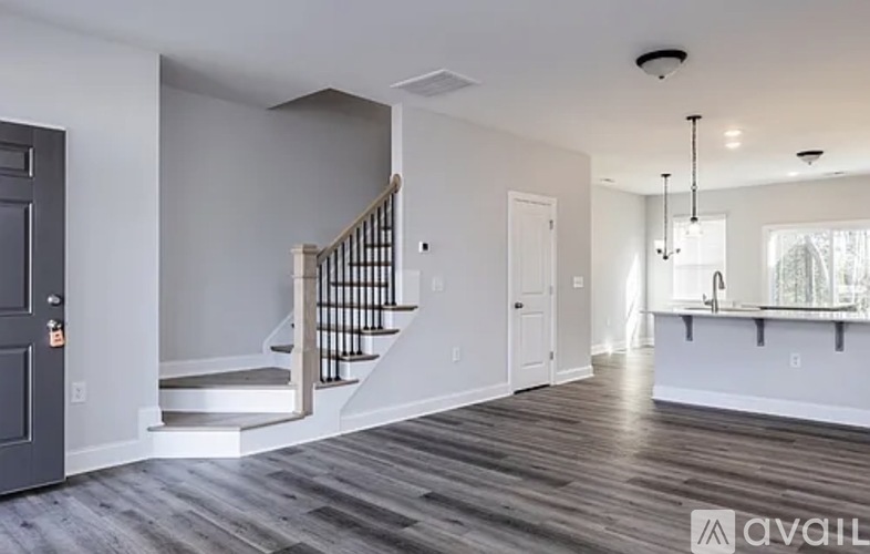 A spacious living room with a staircase leading to the upper floor.