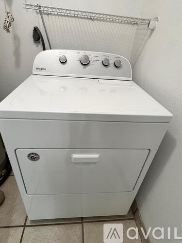 A white Whirlpool washing machine in a laundry room.