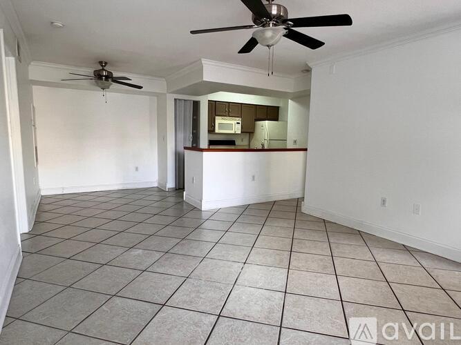 A spacious room with a ceiling fan and tiled flooring.