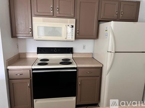A kitchen with brown cabinets and a white refrigerator.