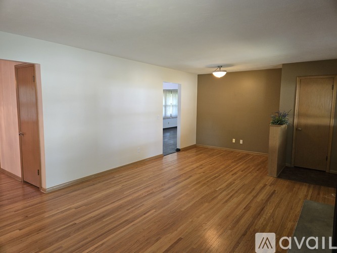 A room with wooden flooring and a window with blinds.
