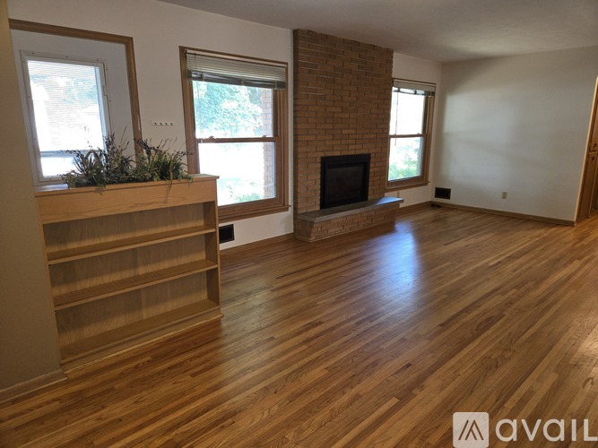 A living room with a fireplace and wooden floors.