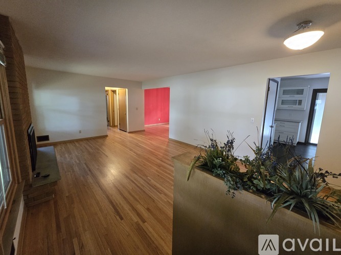 A room with wooden floors and a television on the left side.