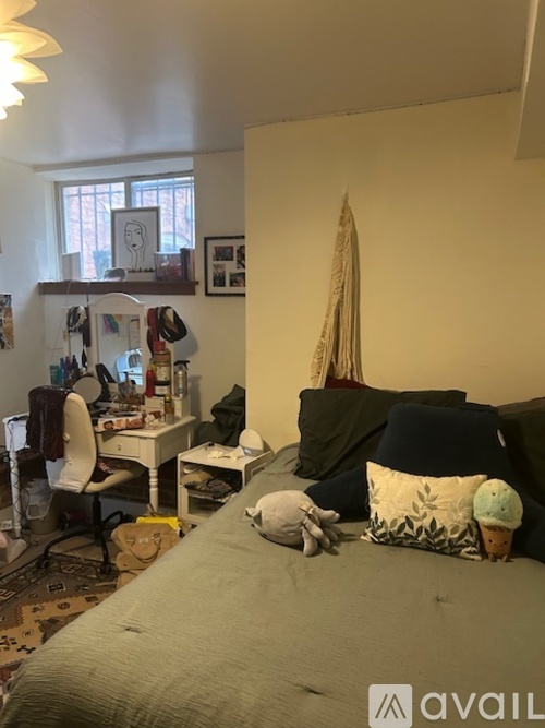 A bedroom with a bed, desk, and chair.