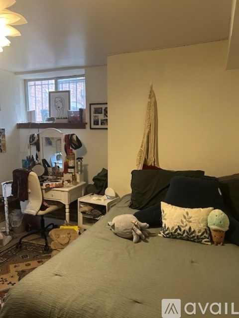 A bedroom with a bed, desk, and chair.