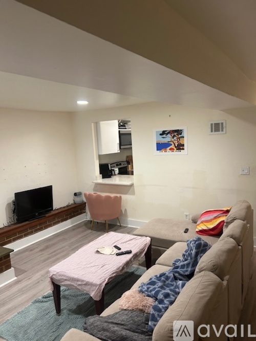 A living room with a couch, chair, and television.