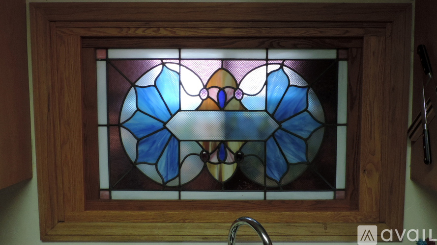 A stained glass window in a wooden frame.