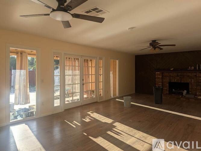 A living room with a fireplace and a ceiling fan.