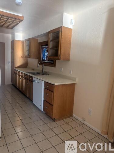 A kitchen with wooden cabinets and a white dishwasher.