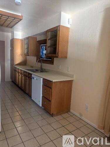 A kitchen with wooden cabinets and a white dishwasher.
