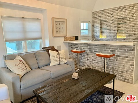 A living room with a grey couch and a wooden coffee table.