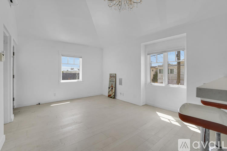 A spacious room with a large window and a wooden floor.