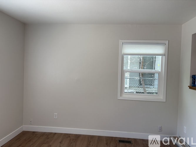 A room with a window and wooden flooring.