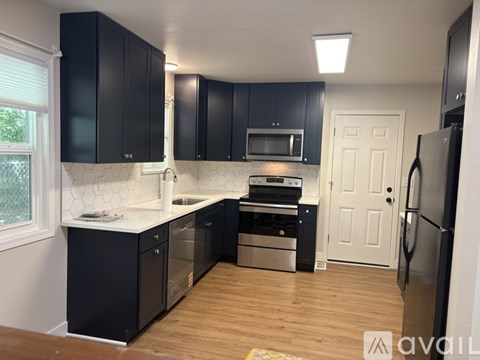 A kitchen with black cabinets and stainless steel appliances.