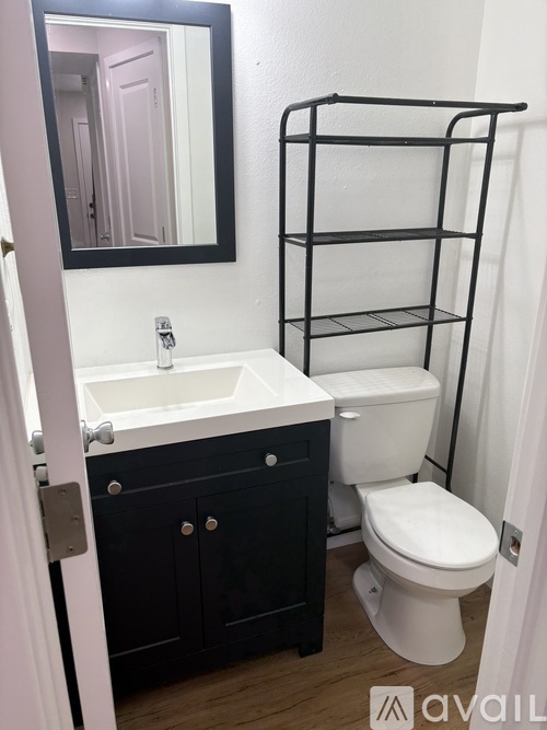 A bathroom with a sink, toilet and a mirror.