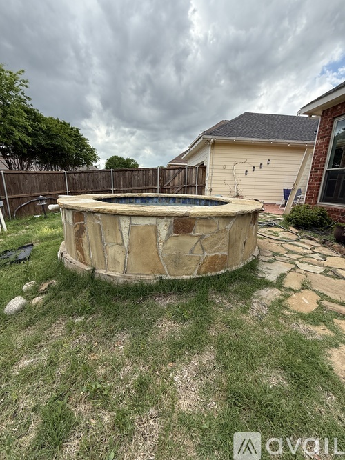 A stone pool surrounded by a grassy area.