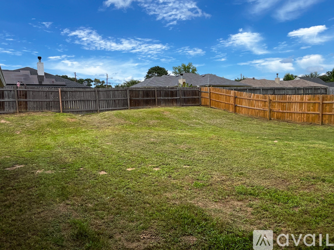A backyard with a wooden fence and a grassy area.