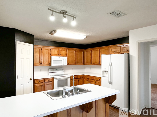 A kitchen with wooden cabinets and a white countertop.