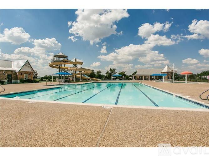 A large swimming pool with a diving board and a small building in the background.